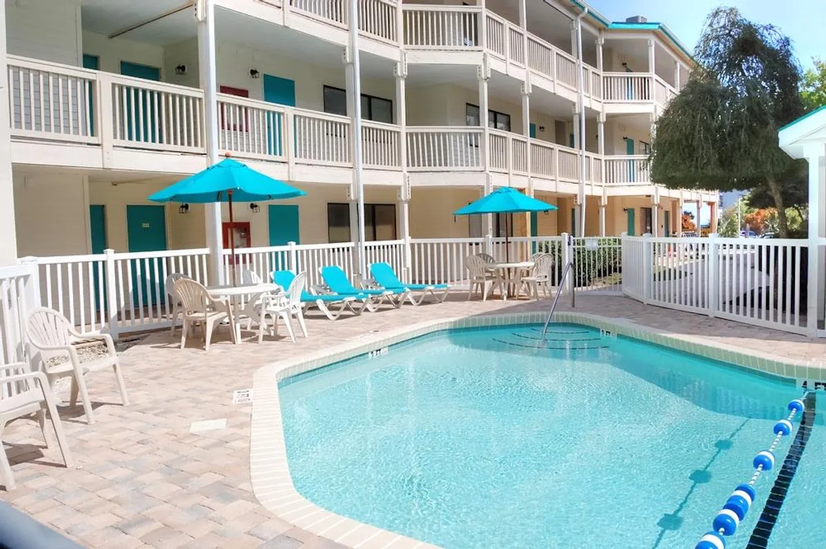 A sparkling swimming pool surrounded by lounge chairs and umbrellas, inviting guests to relax, sunbathe, or enjoy a refreshing swim. The area exudes calm, offering opportunities for socializing or quiet relaxation under the sun or stars.